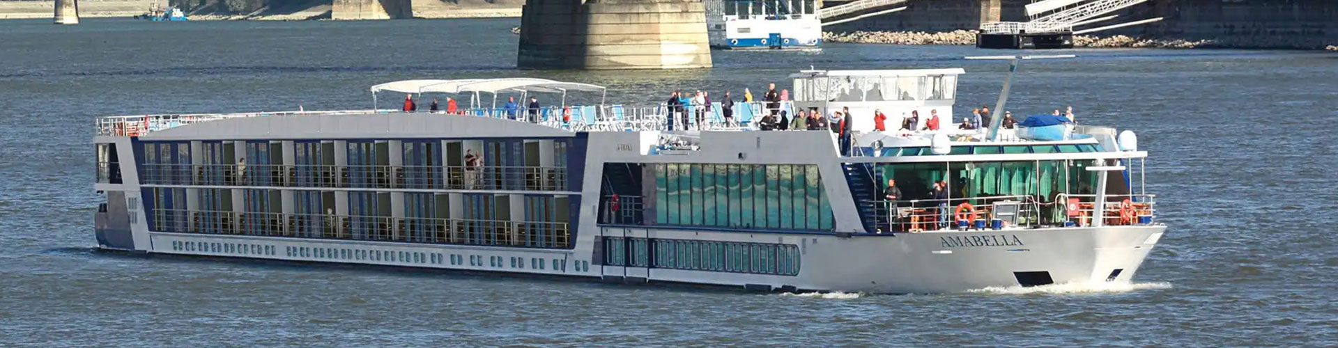 Passengers on the sun deck of a modern river cruise ship under way