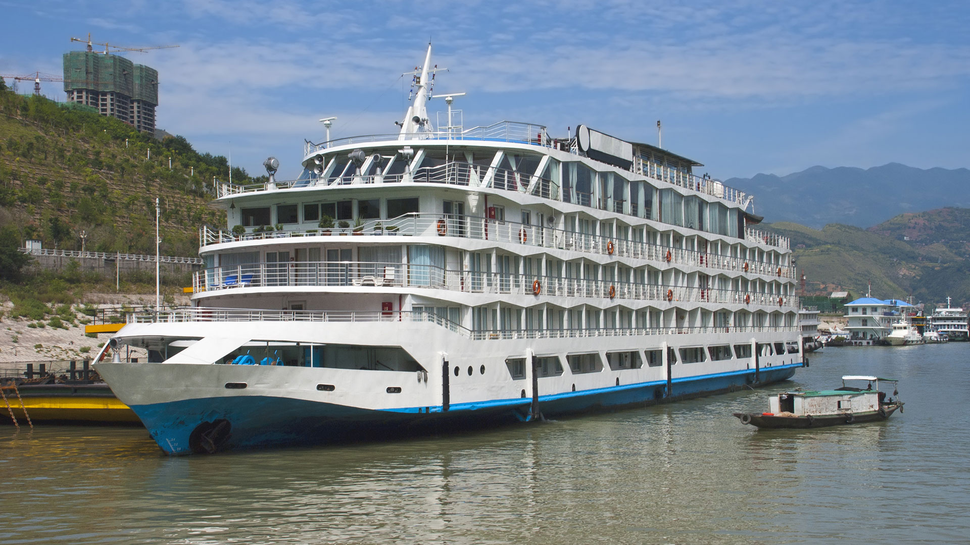 Large multi-deck river cruise ship moored at a riverside port